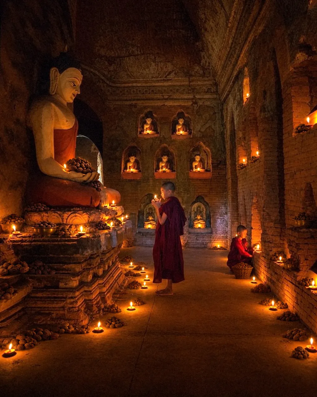 A candlelit Himalayan temple with monks and Haritaki fruit